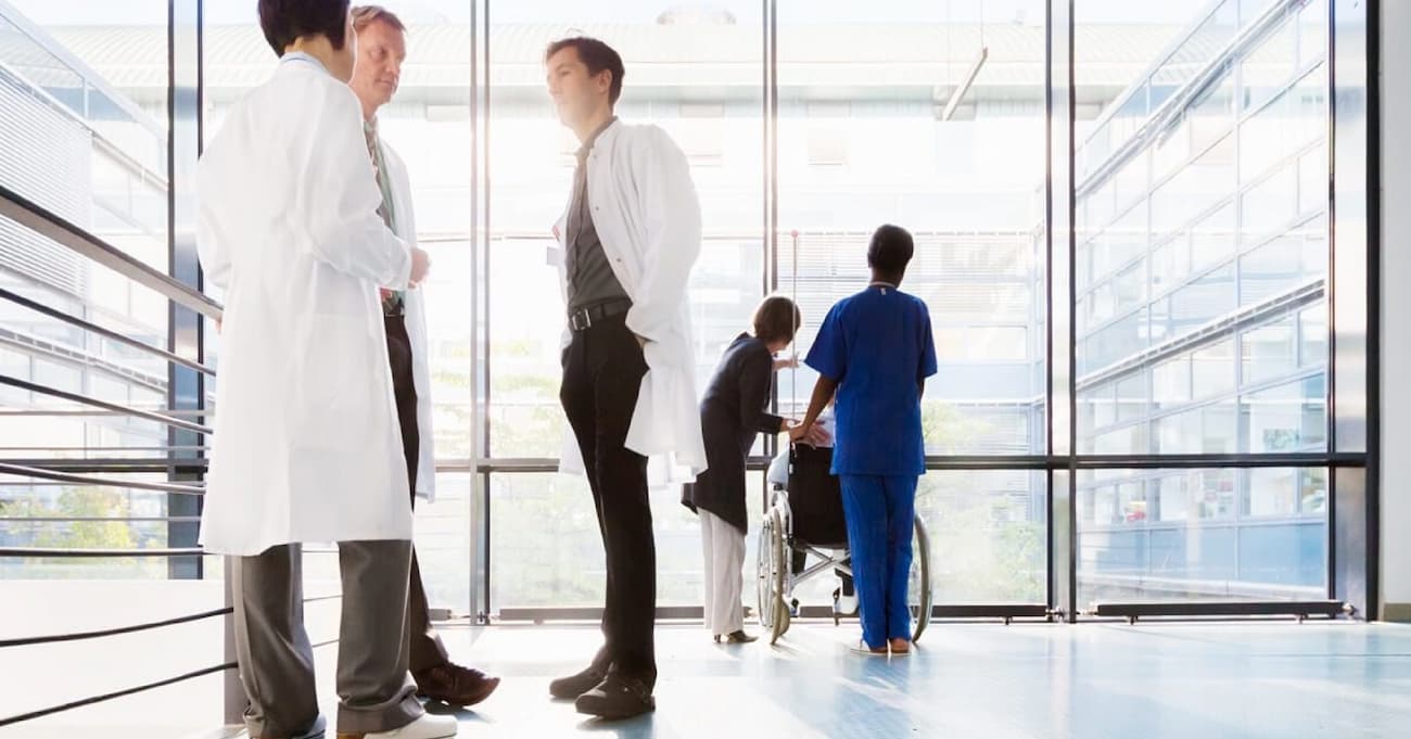 doctors conferring in a hospital setting overlooking an atrium